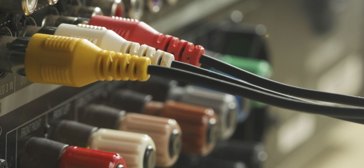 Yellow, red and  white audio cables and connectors on music amplifier back panel